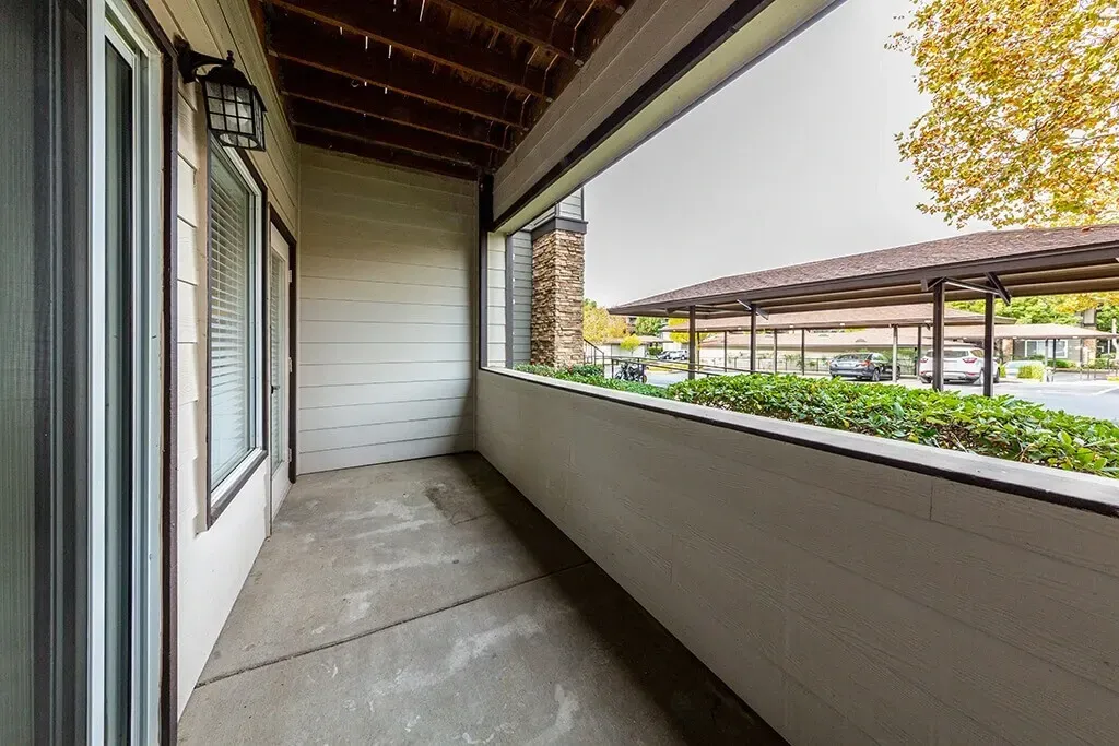 Balcony overlooking covered parking and landscaping.