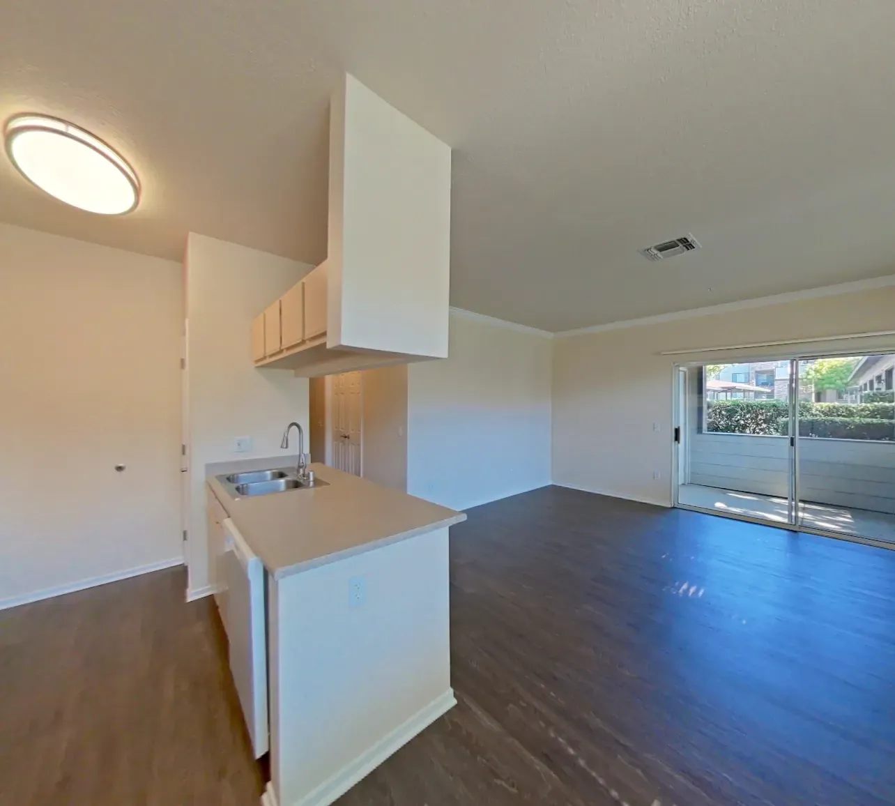 Modern kitchen and living area with a sliding glass door leading to a patio.