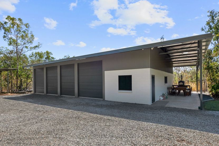 Modern single-story house with white and gray exterior, covered patio, and gravel driveway under a blue sky — Invision NT in Gove, NT