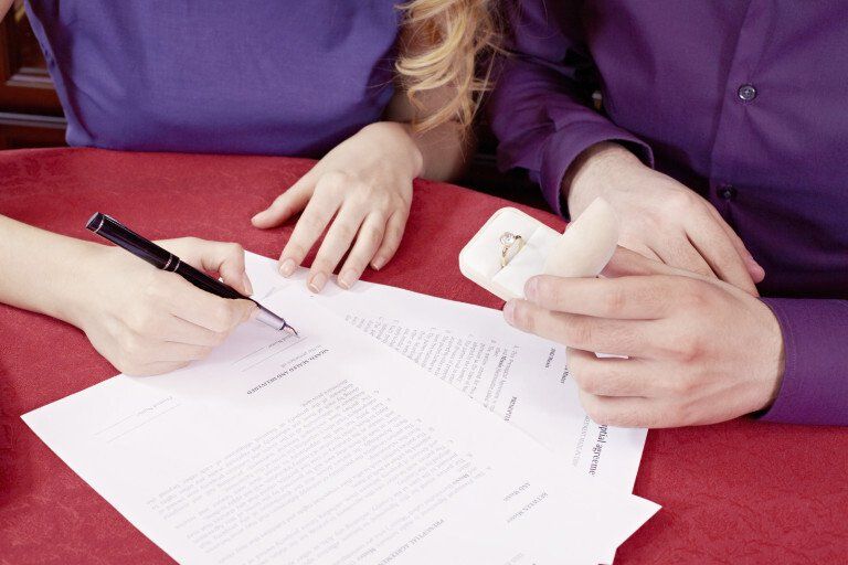 two people write on pieces of paper