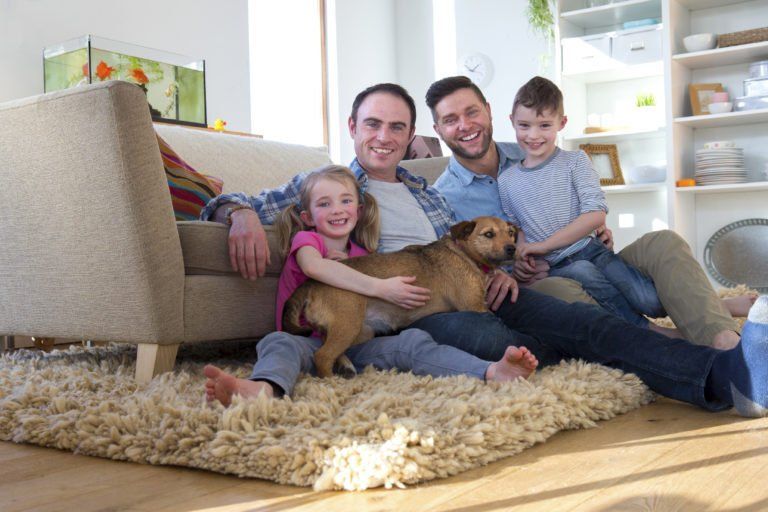 two men sit with their family