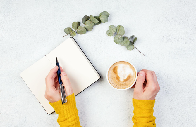 Woman taking notes in a meeting room while colleagues sit in the background