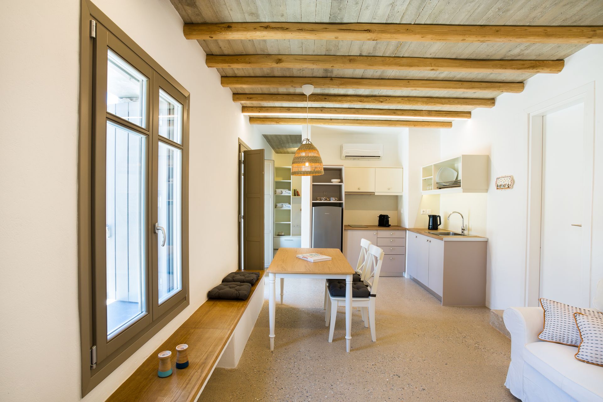A living room with a table and chairs and a kitchen