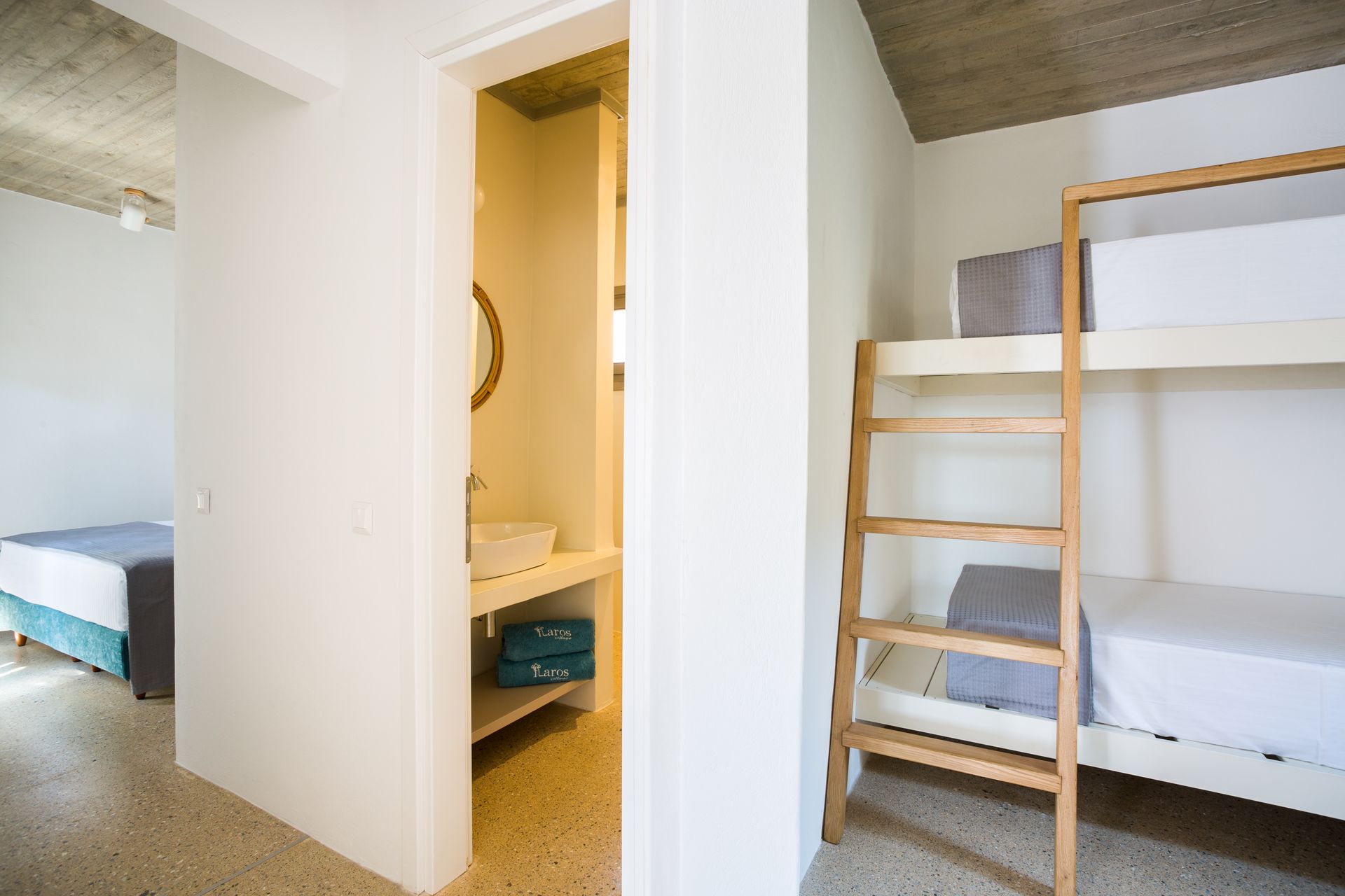 A bedroom with bunk beds and a bathroom with a sink.