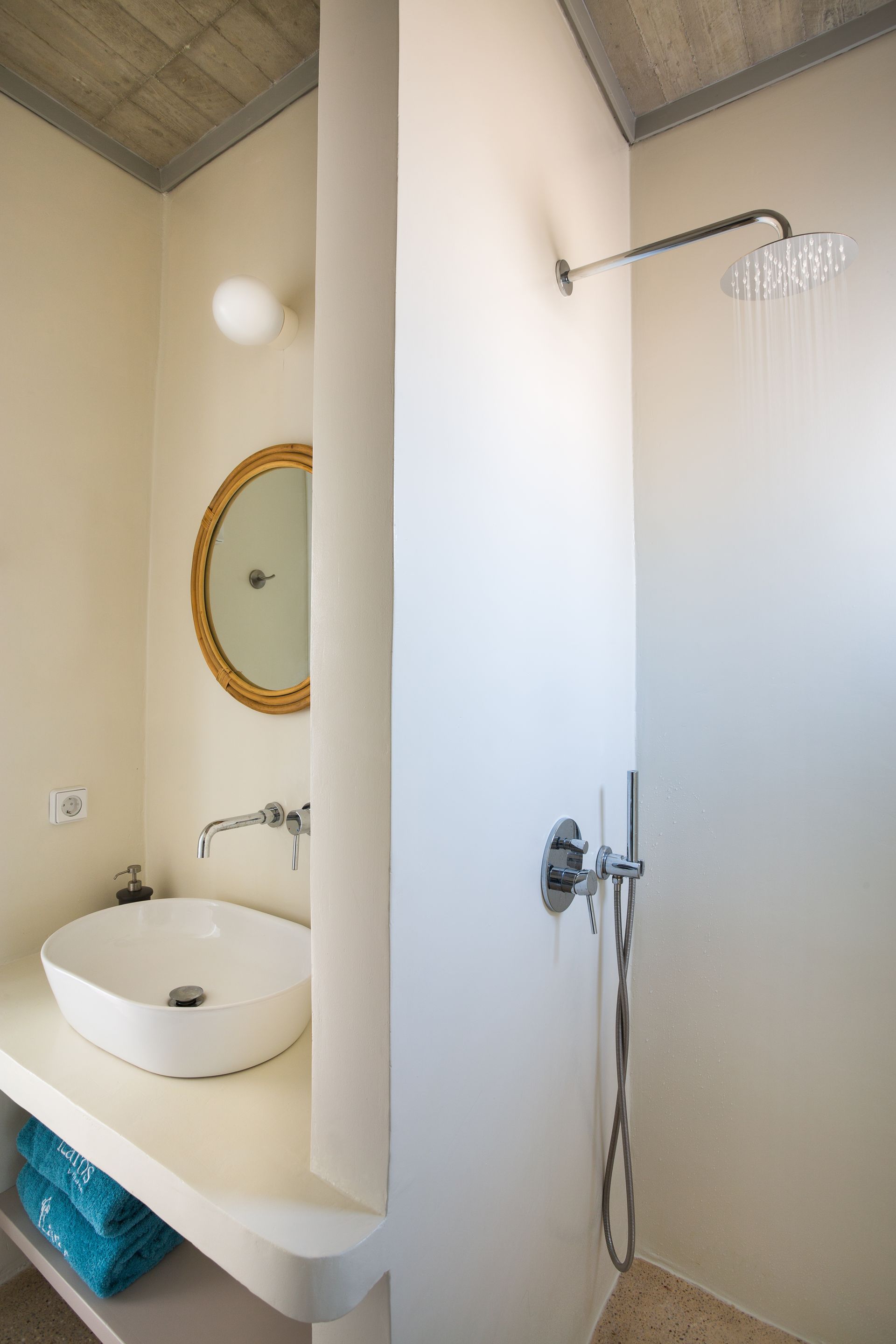A bathroom with a sink , mirror and shower.