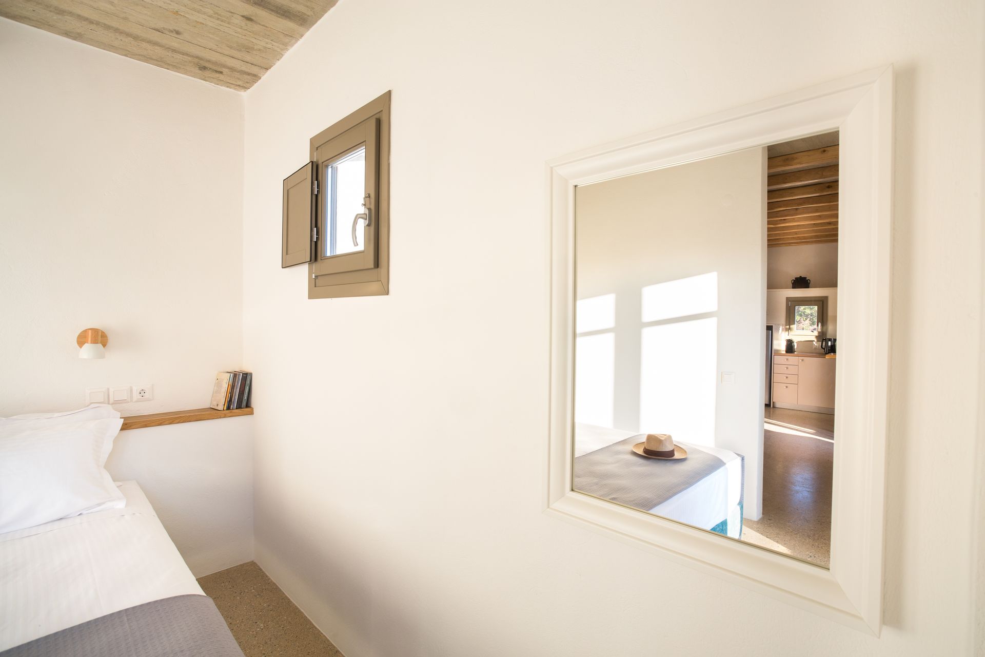 A bedroom with a bed and a mirror on the wall.