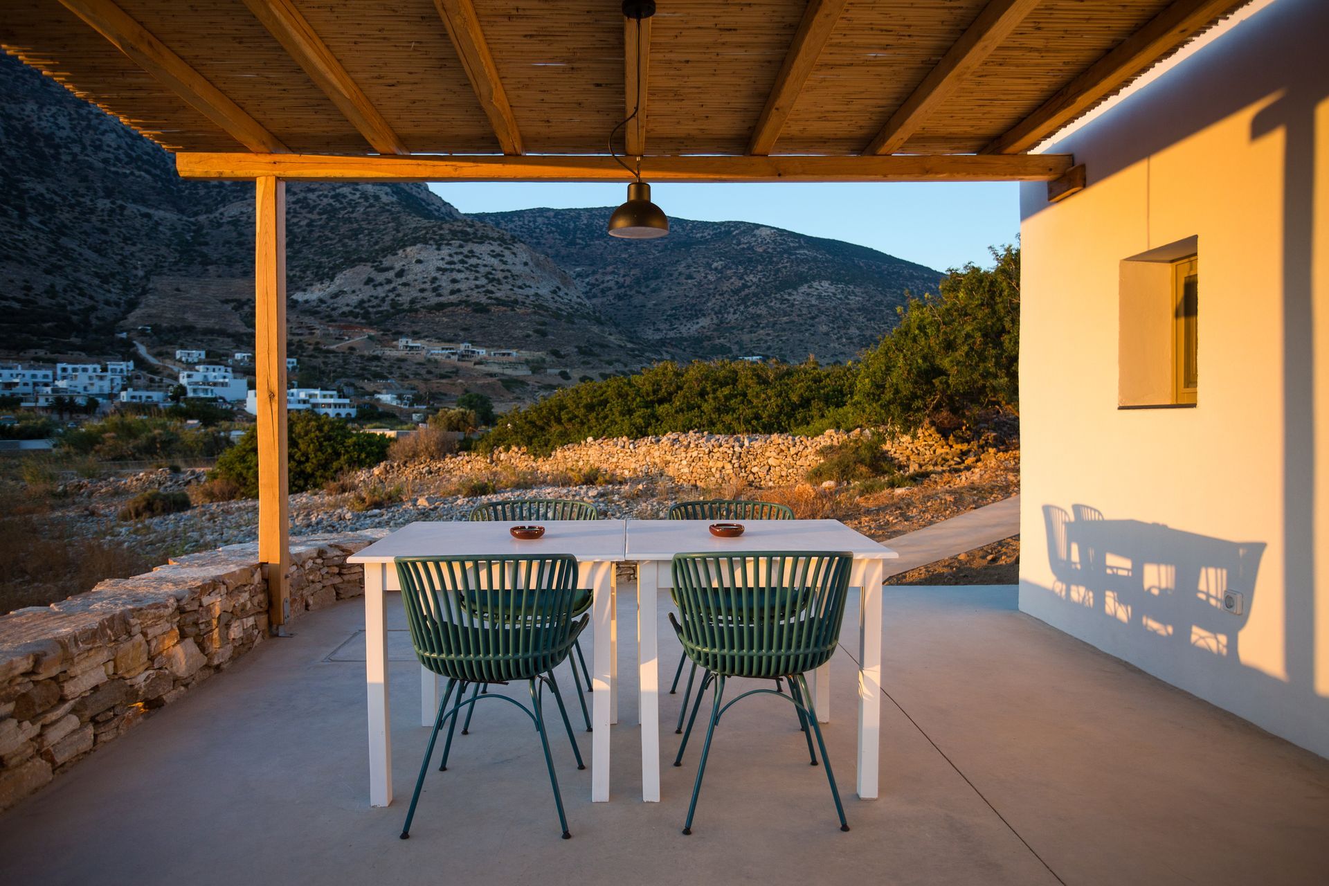 A table and chairs on a patio with mountains in the background.