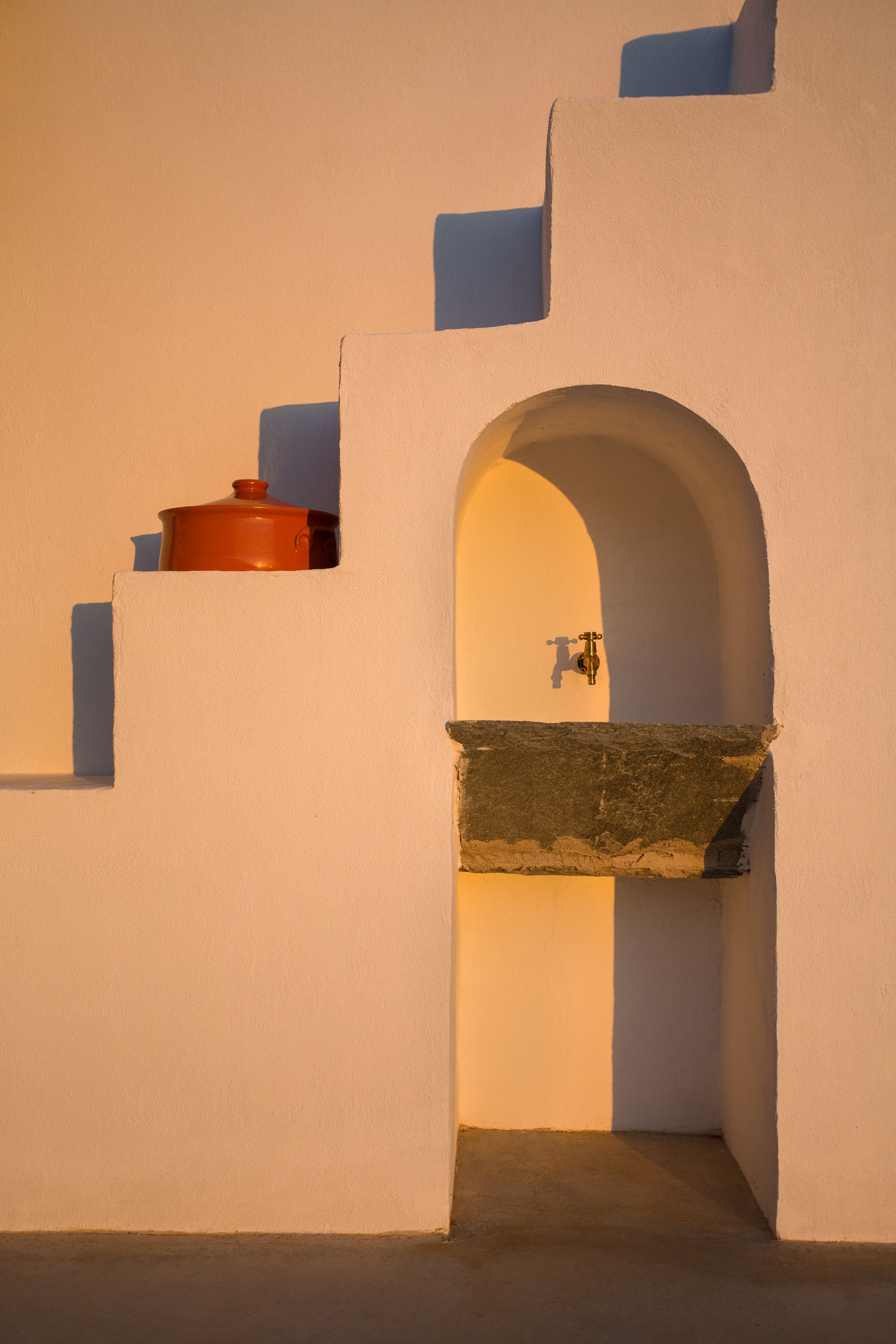A white wall with stairs and a sink in it