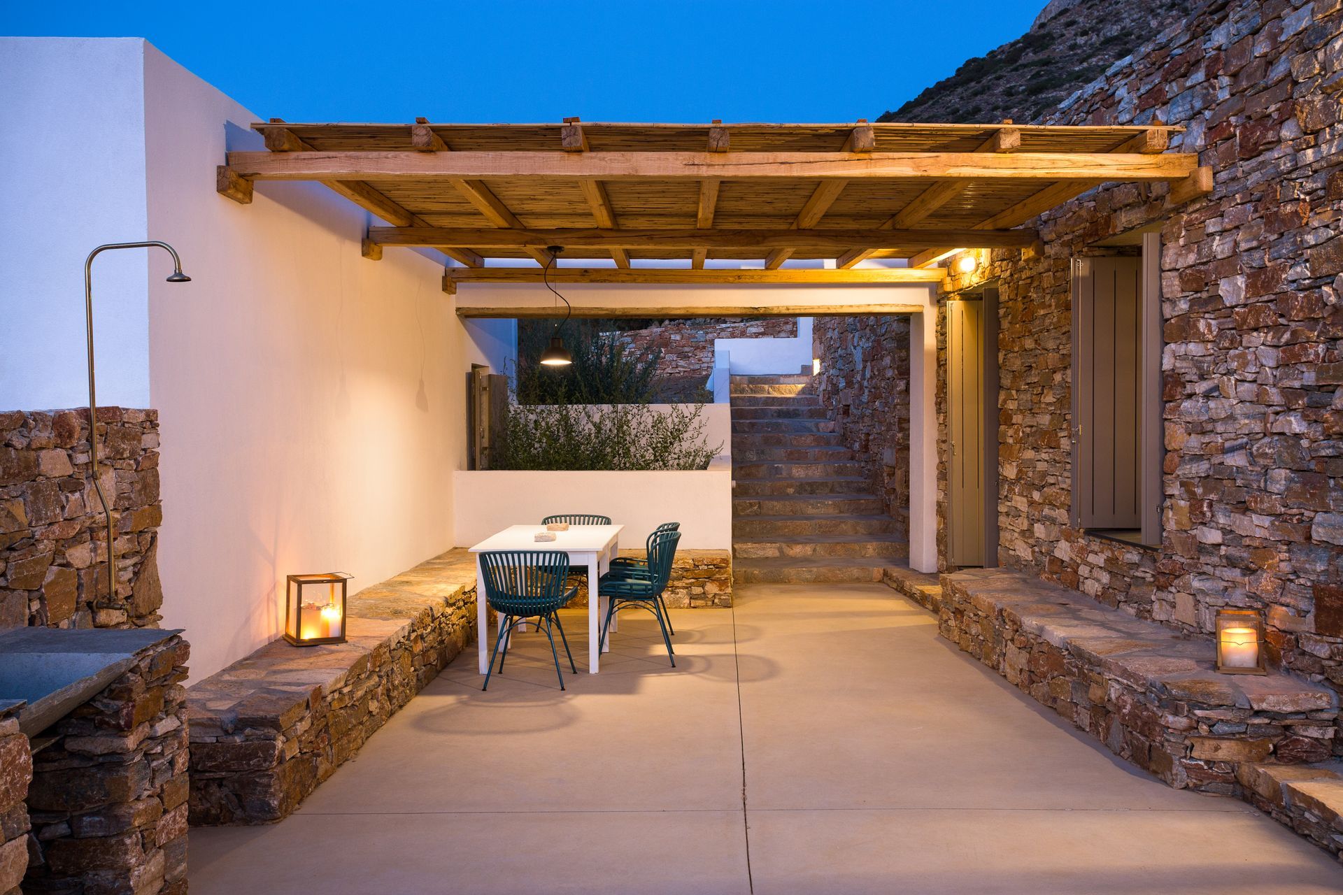 A patio with a table and chairs under a pergola.