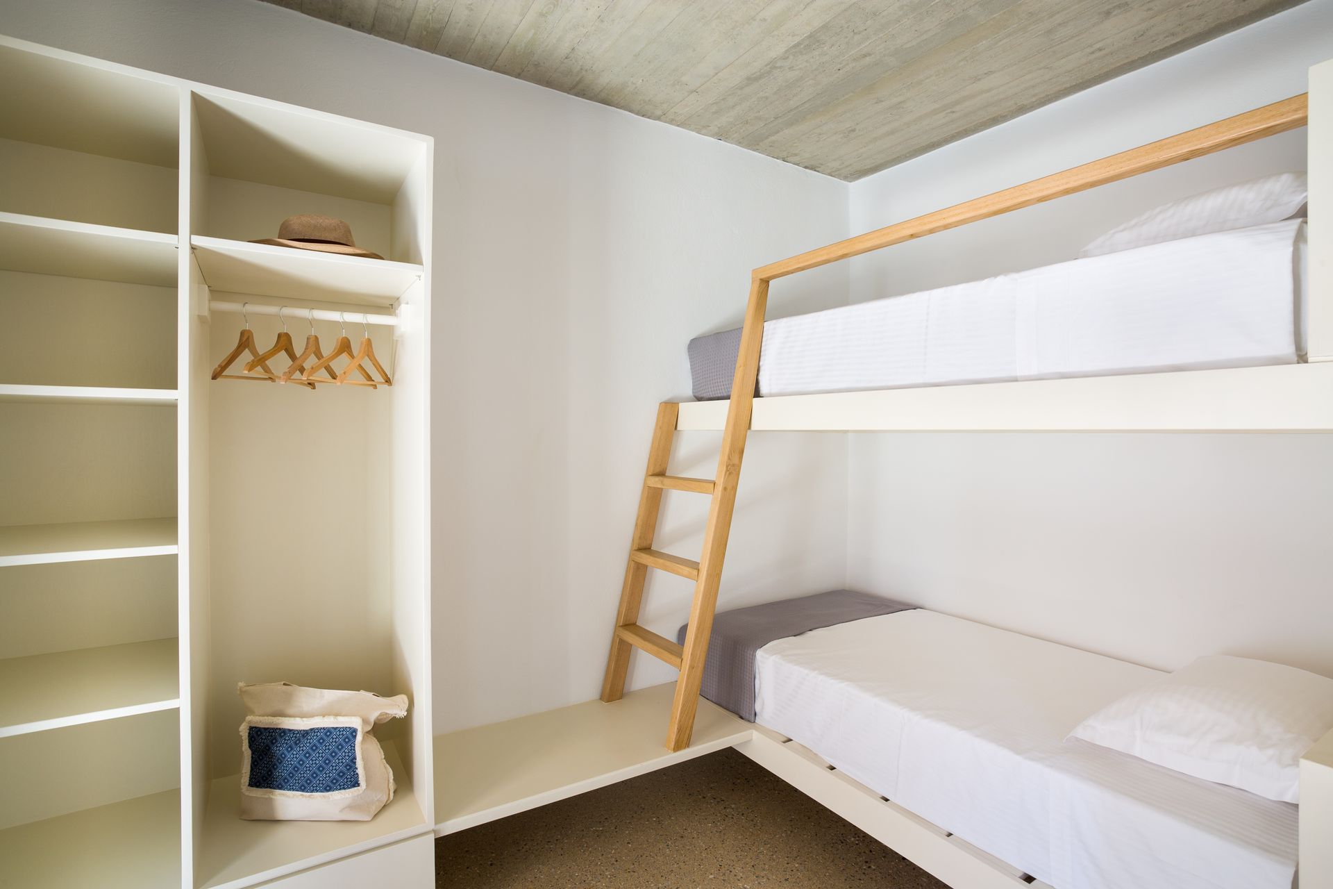 A bedroom with two bunk beds and a ladder.