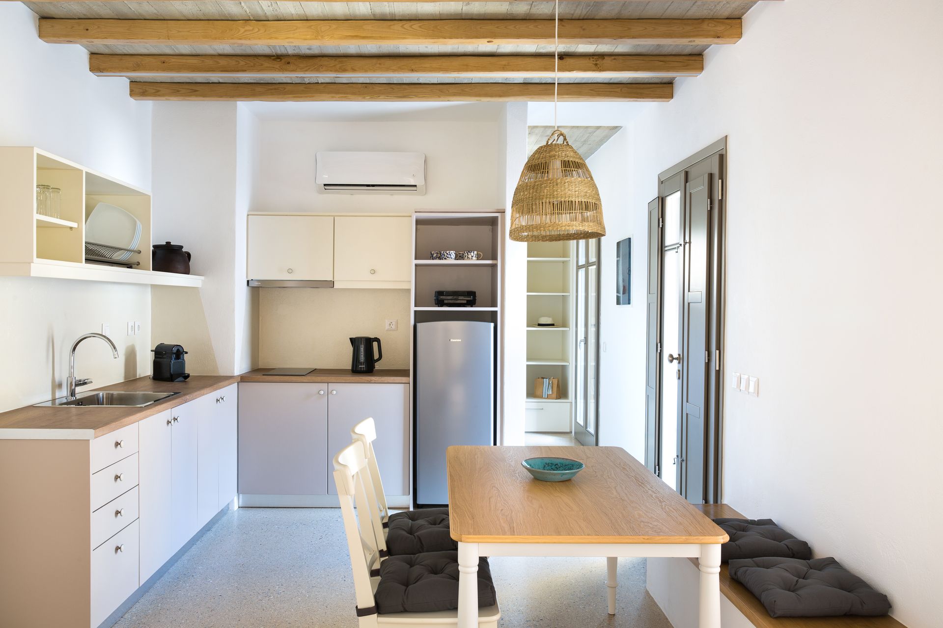 A kitchen with a table and chairs and a refrigerator.