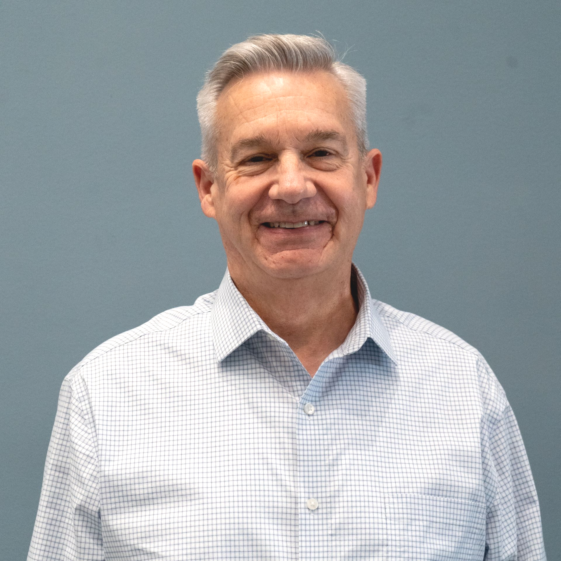 A man in a plaid blue and white button down shirt