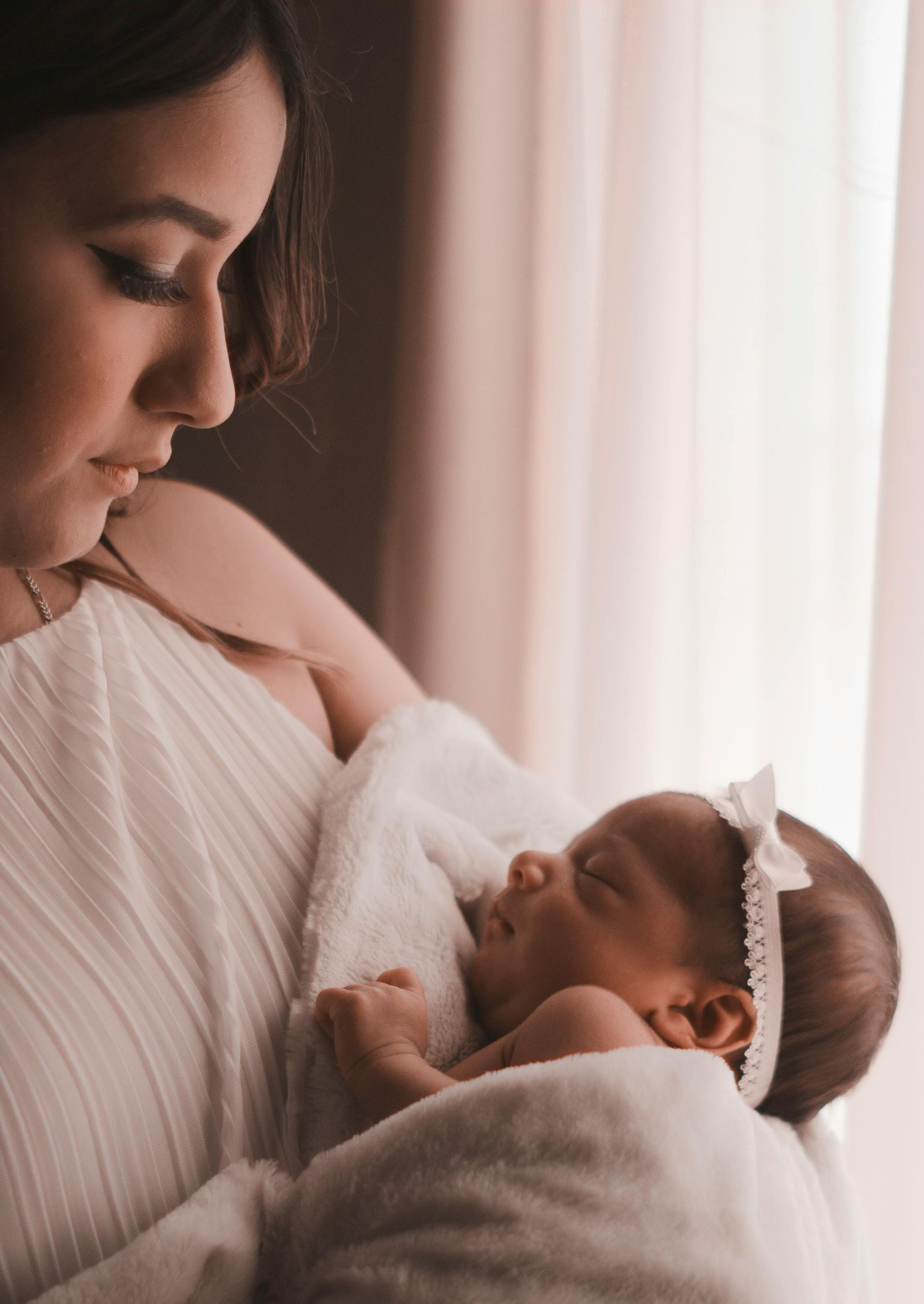 A woman is holding a newborn baby in her arms.