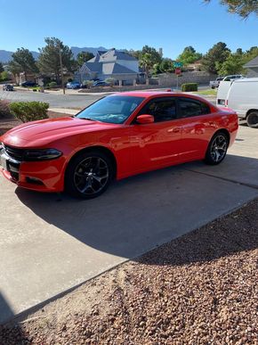 Red sports sedan parked in a sunny suburban driveway