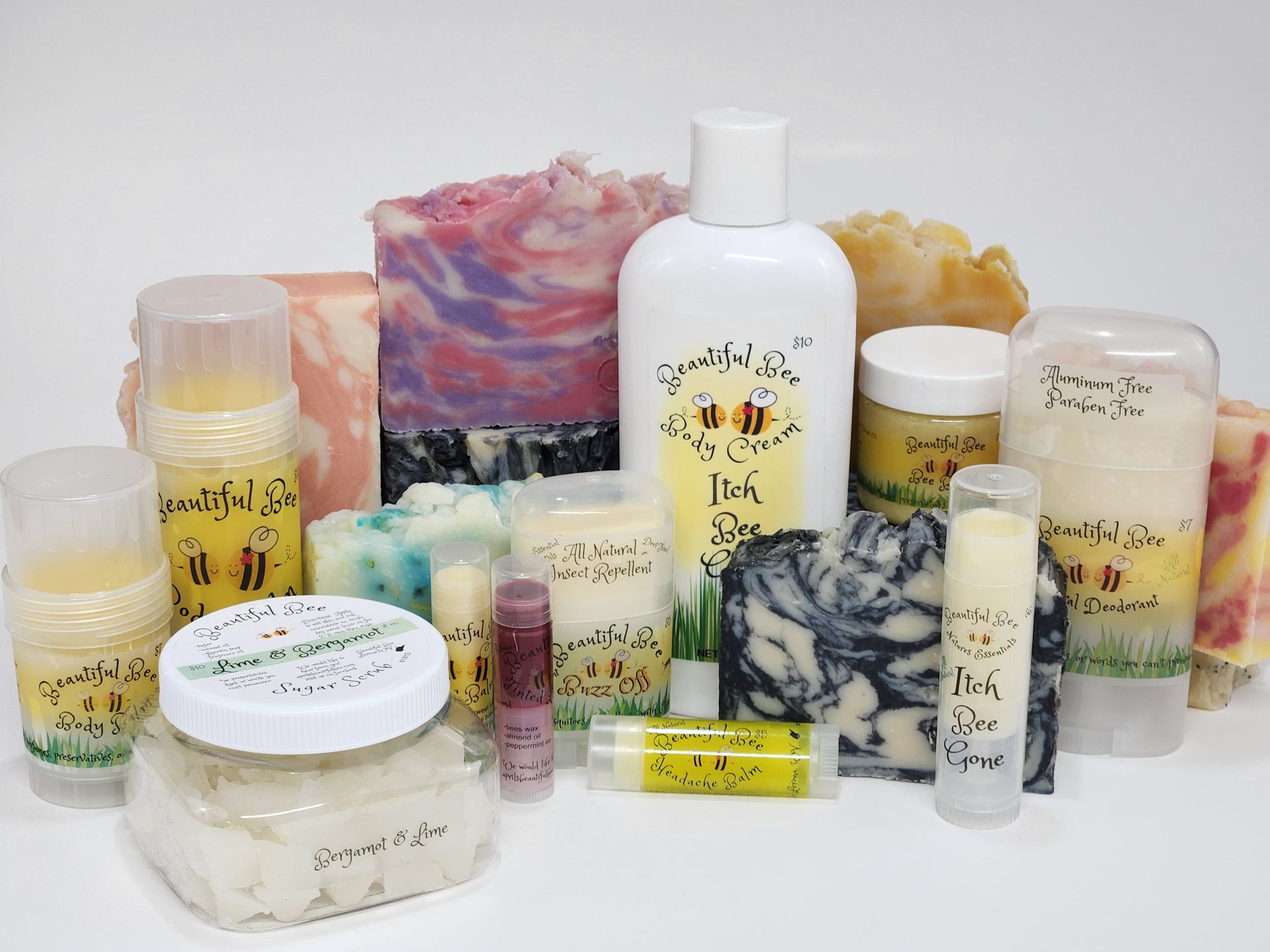 A variety of soaps, lotions, lip balms, and candles are displayed on a table.