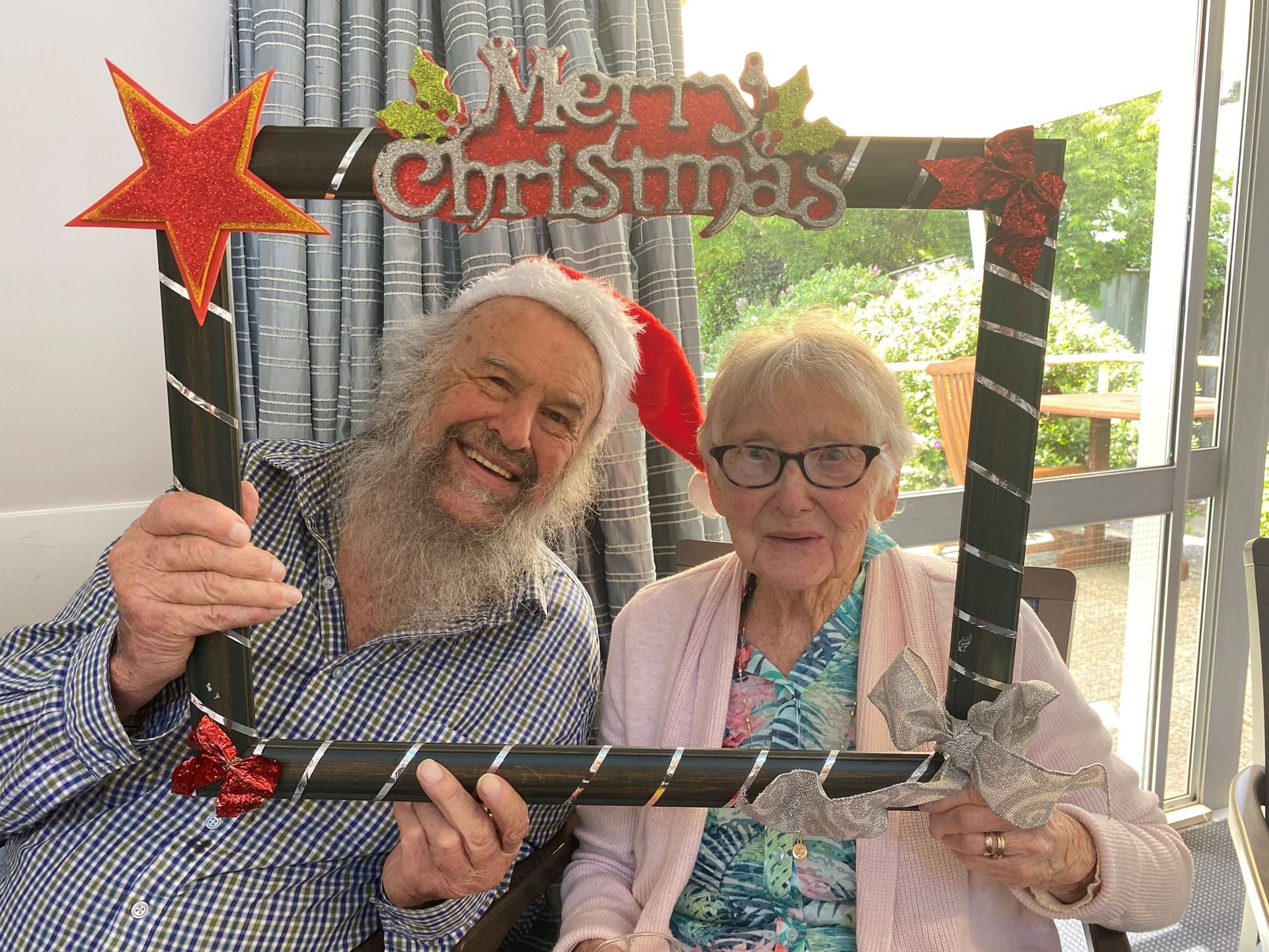 A man and a woman are holding a christmas photo frame.