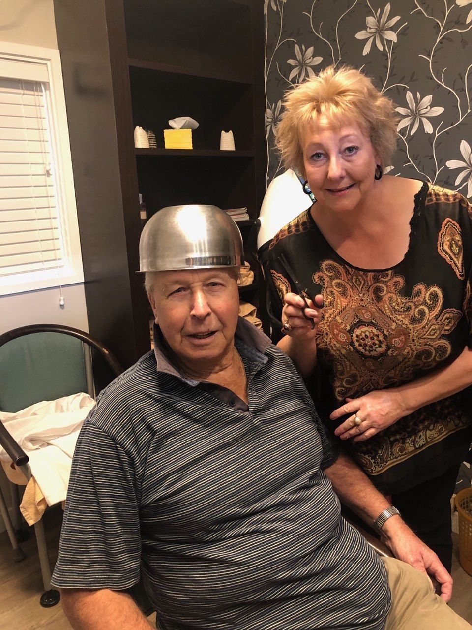 A woman is standing next to a man wearing a helmet.