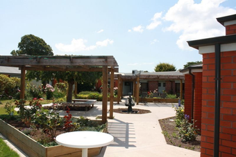 a white table sits in the middle of a garden