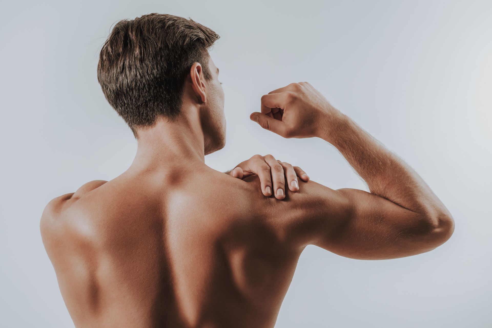 As costas de um homem sem camisa flexionando os músculos.