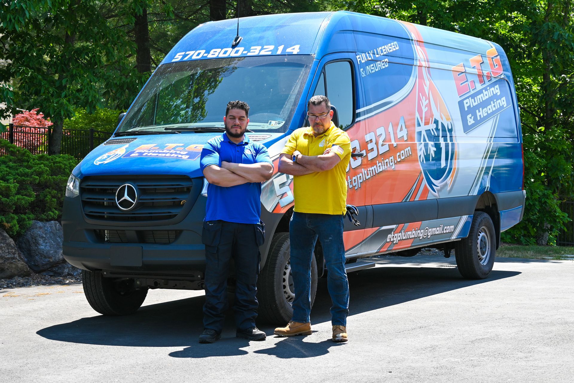 Two men are standing in front of a mercedes van.