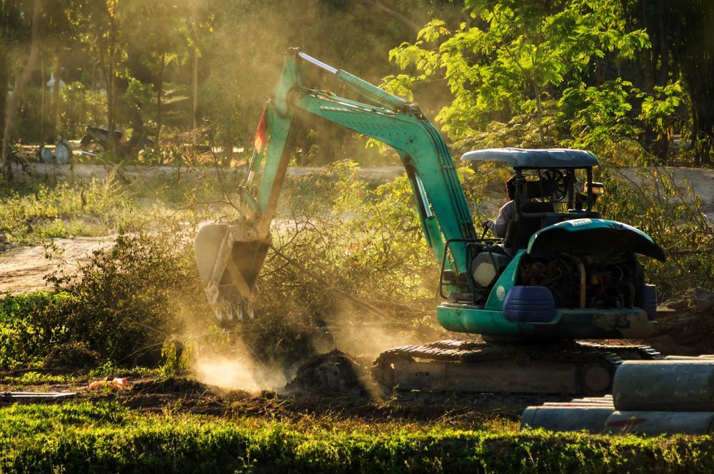 Green Excavator Digging Earth On A Sunny Day — Northern Rivers Acreage Mowing in Pimlico, NSW