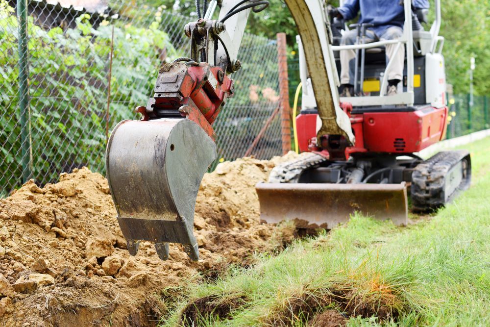 Mini Excavator Digging A Trench Near A Fence And Grass — Northern Rivers Acreage Mowing in Pimlico, NSW