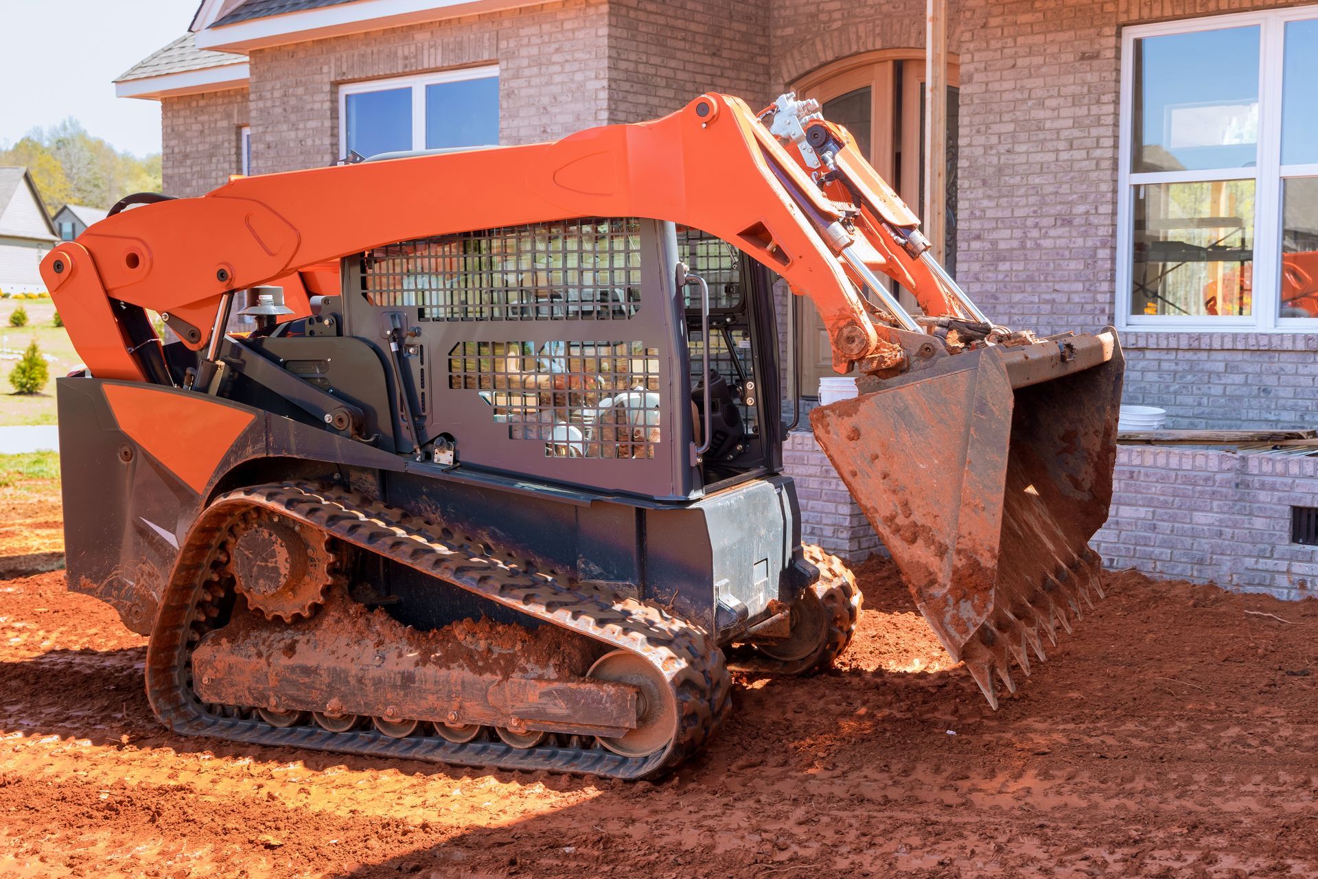 Orange Track Loader With Dirt-filled Bucket On A Construction Site — Northern Rivers Acreage Mowing in Ballina, NSW