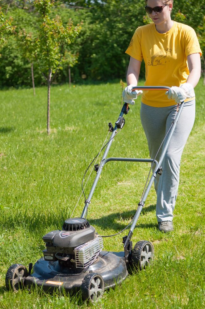 Person In Yellow Shirt Mowing A Grassy Lawn — Northern Rivers Acreage Mowing in Pimlico, NSW