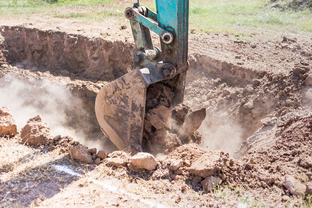 Excavator Digging A Trench In Dirt, Kicking Up Dust — Northern Rivers Acreage Mowing in Alstonville, NSW