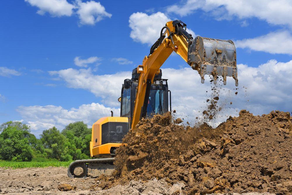 Yellow Excavator Digging Soil Outdoors — Northern Rivers Acreage Mowing in Byron Bay, NSW