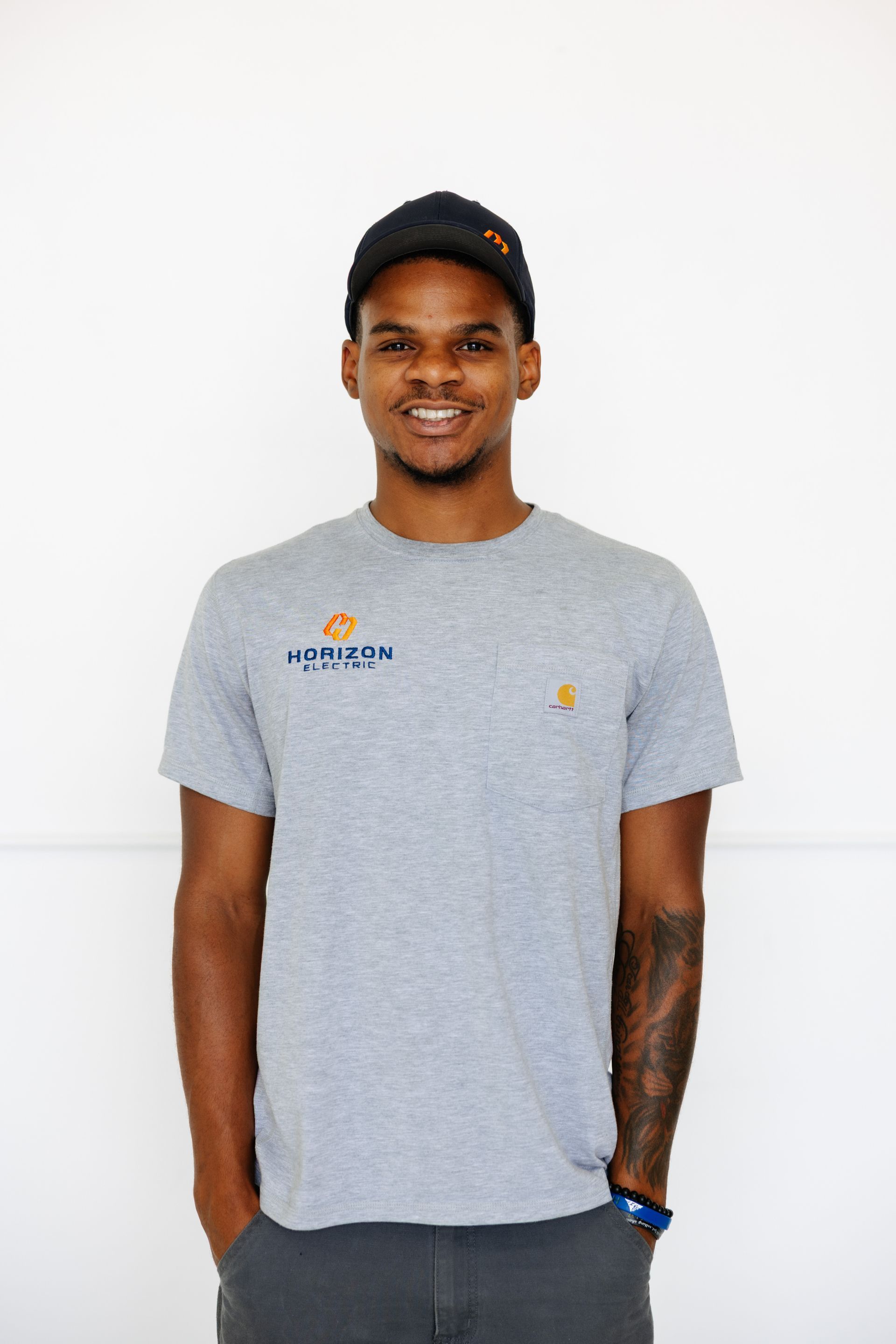 A person in a blue work shirt and cap with a