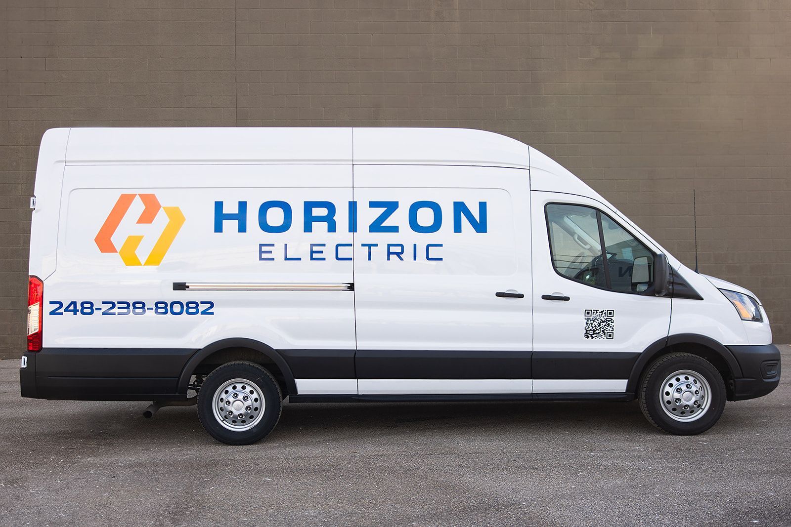 A white Horizon Electric service van parked against a plain wall with the company logo and phone number on the side.