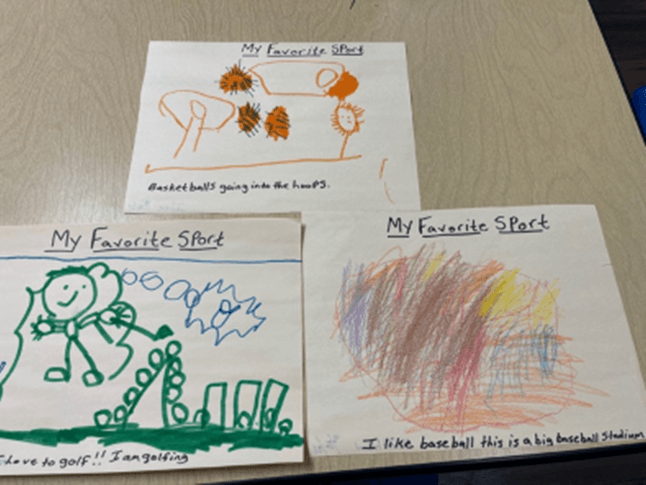 Three children 's drawings on a table one of which says my favorite sport