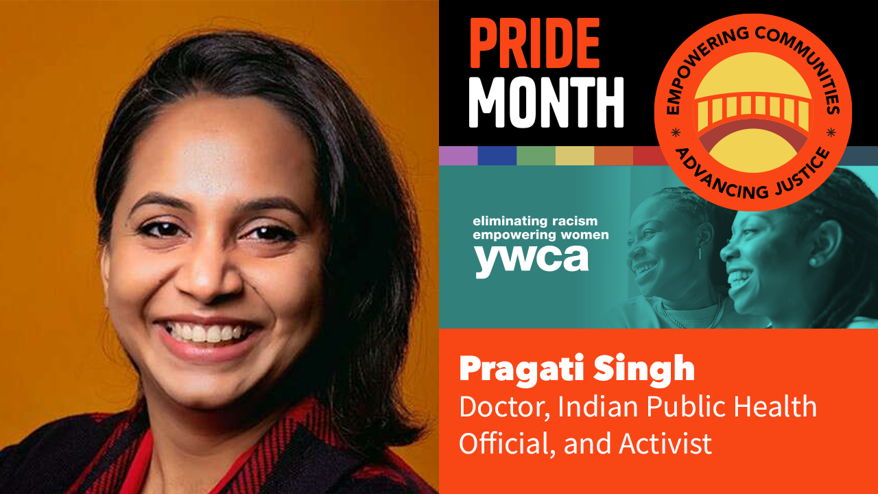 A woman is smiling in front of a sign that says pride month