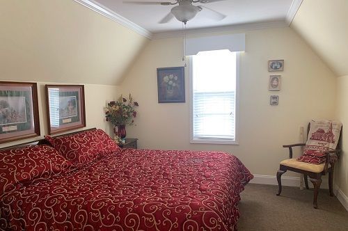 A bedroom with a king size bed and a chair