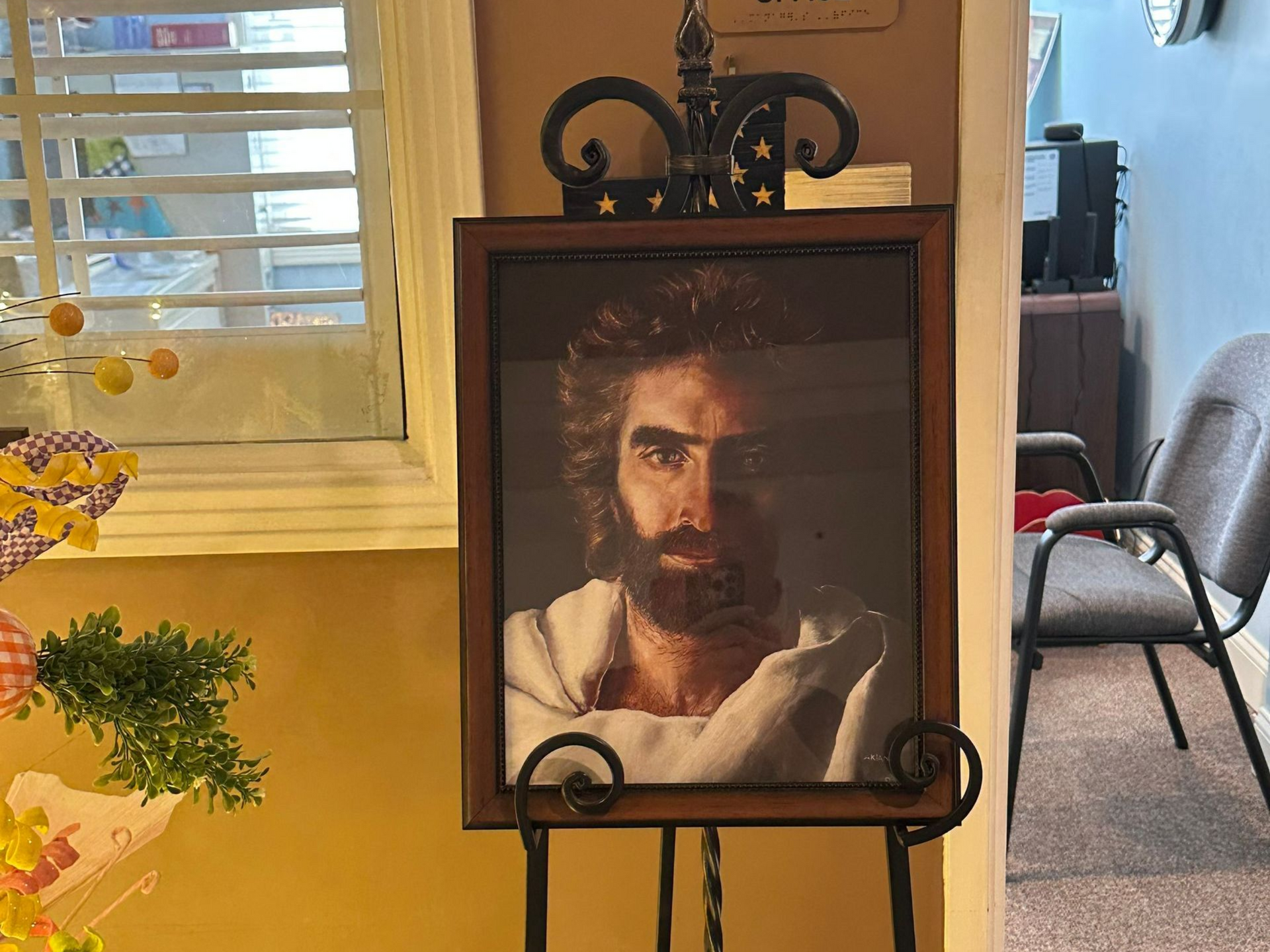 Portrait of Jesus with a beard, in a wooden frame on a black easel. Independent senior living community near Raleigh, NC.