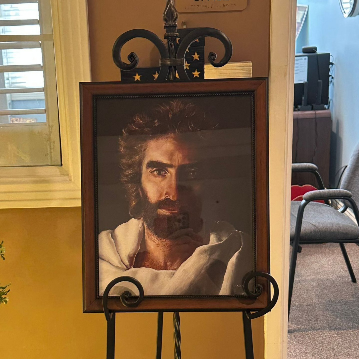 Portrait of Jesus with a beard, in a wooden frame on a black easel. Independent senior living community near Jacksonville, NC.