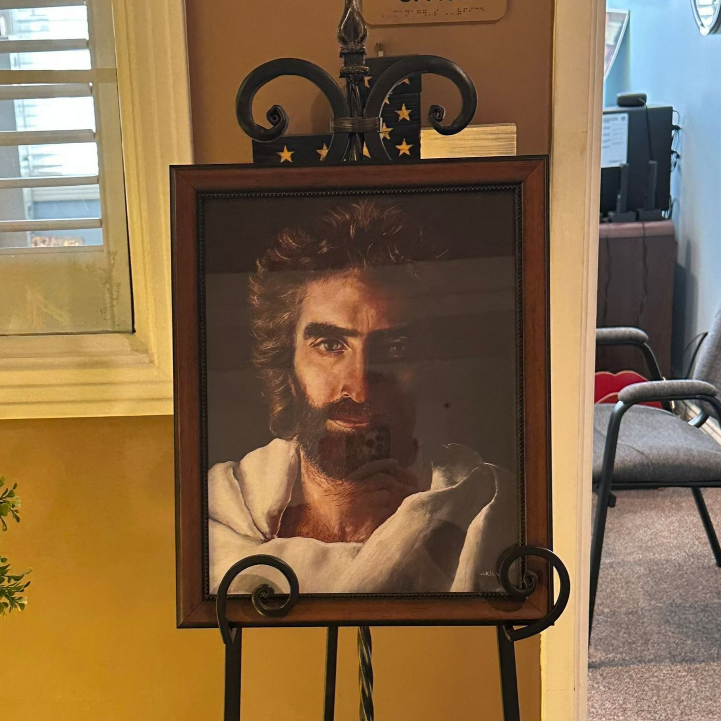 Portrait of Jesus with a beard, in a wooden frame on a black easel. Independent senior living community near New Bern, NC.