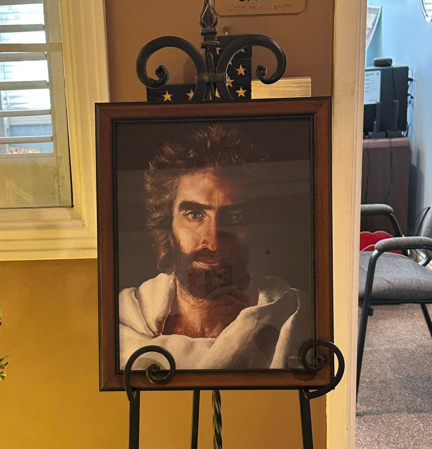 Portrait of Jesus with a beard, in a wooden frame on a black easel. Independent senior living community near Washington, NC.