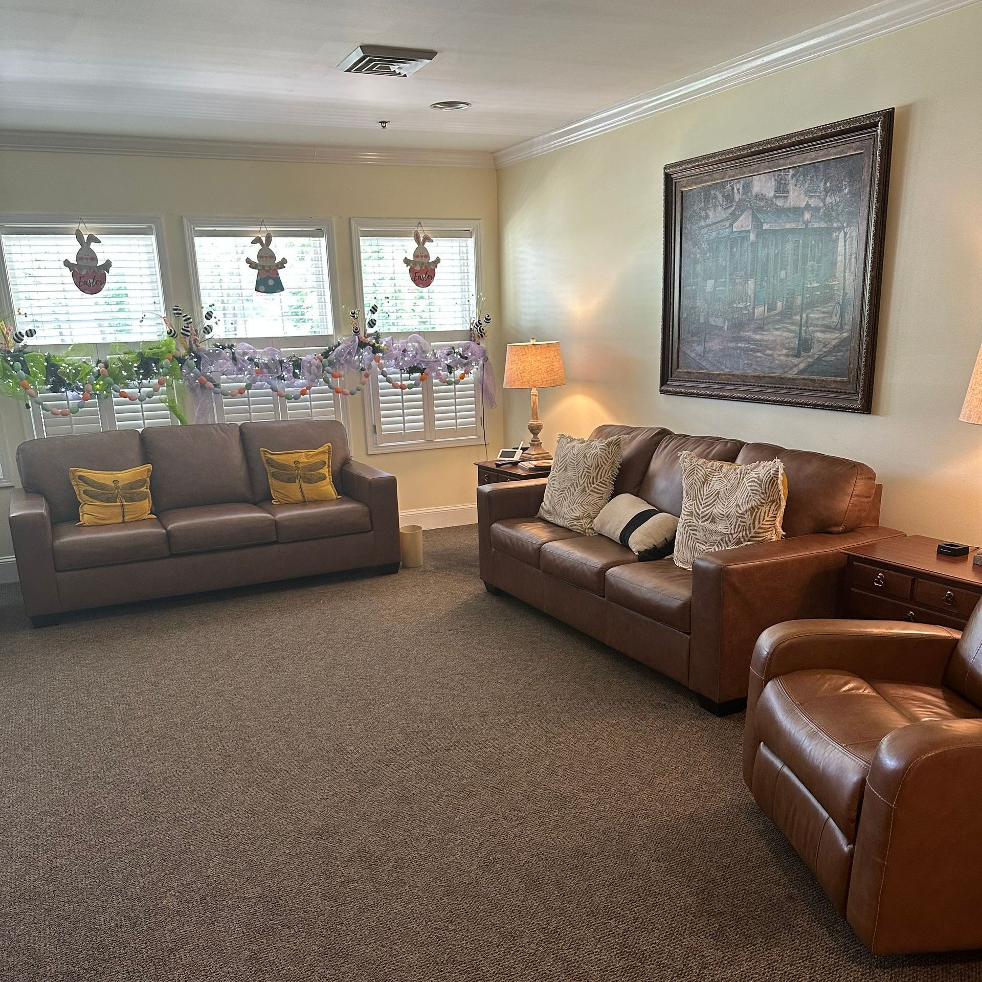 A living room with a couch and two chairs