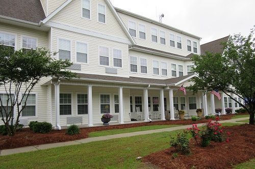 A large white house with a porch and a lot of windows