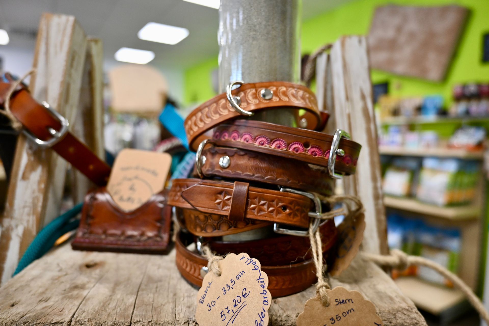 Ein Stapel brauner Lederarmbänder mit rosa Edelsteinen ist in einem Geschäft ausgestellt.