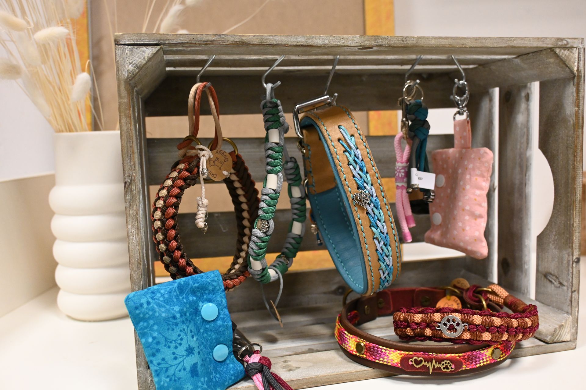 Verschiedene bunte Armbänder und Schmalbänder, ausgestellt auf einem Holzgestell und einem Tablett.