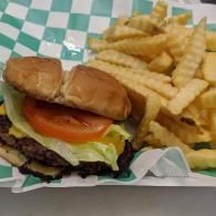 Burger and crinkle-cut fries on a tray lined with green-and-white checkered paper