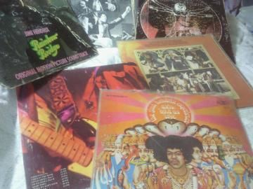 Several colorful vinyl album covers and records laid out together on a flat surface.