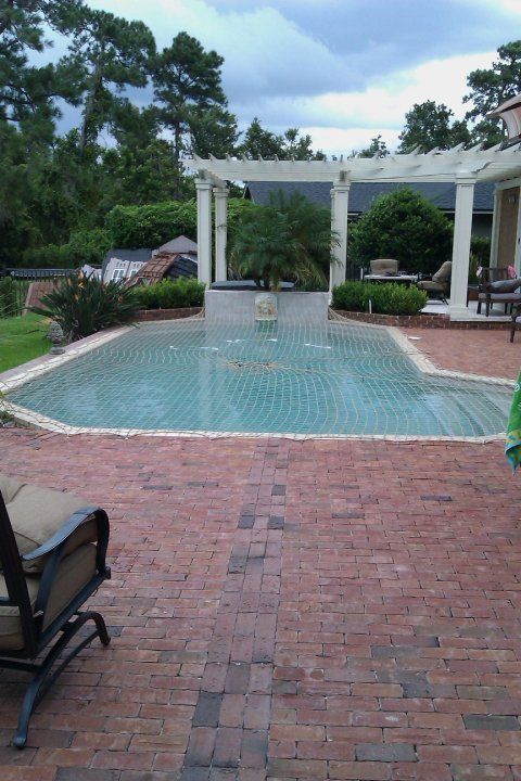 A large swimming pool with a fountain in the middle