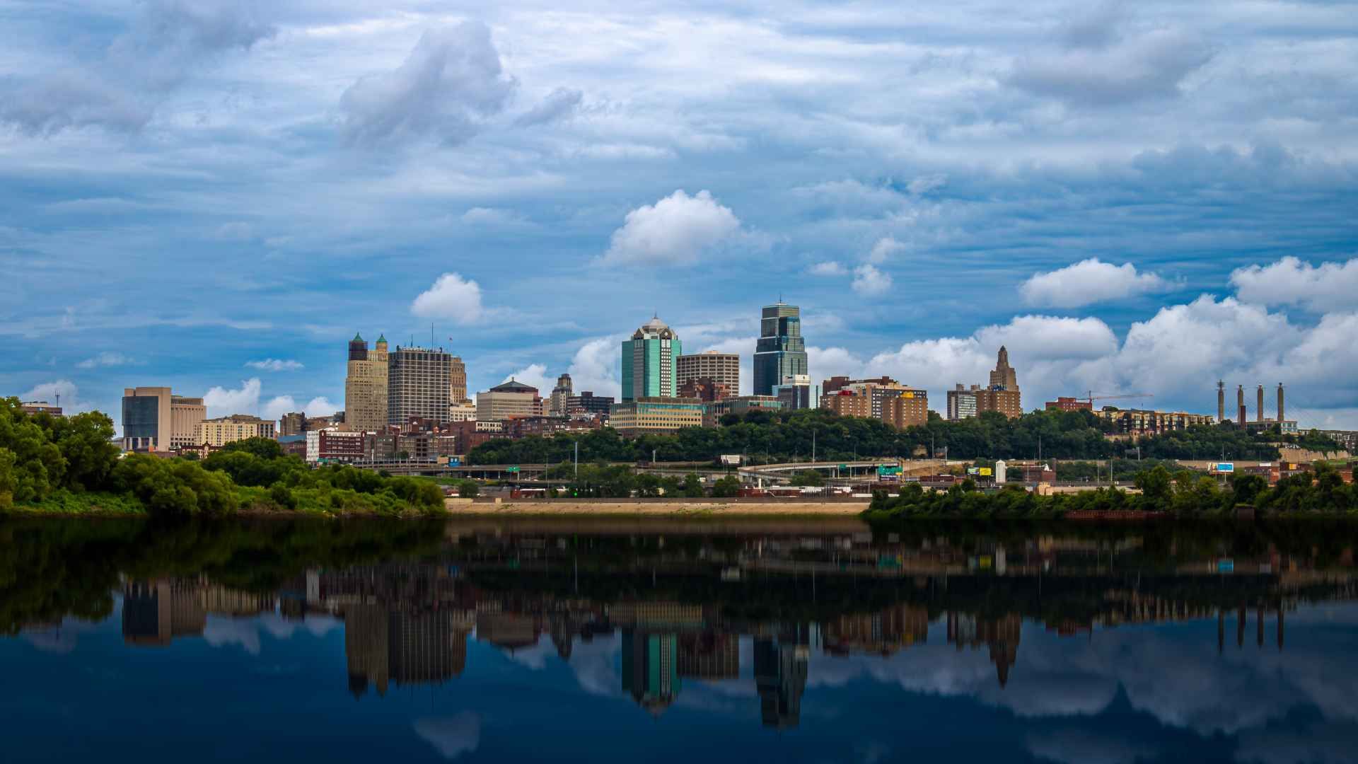 A city skyline is reflected in a body of water.