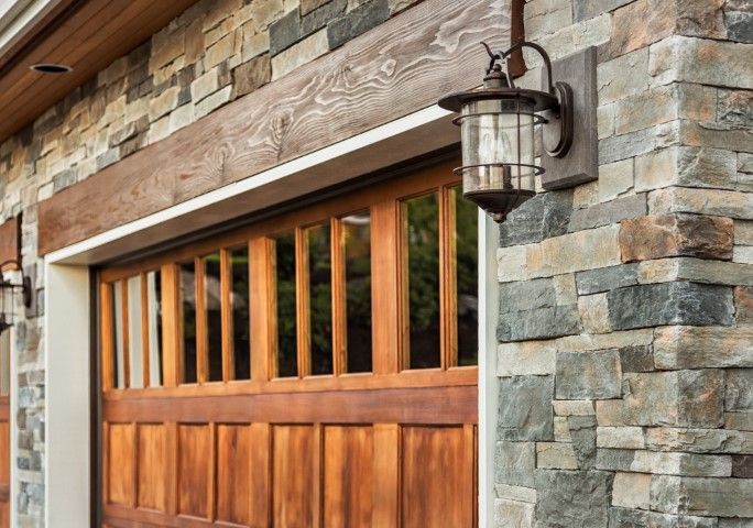 Wood-and-stone garage exterior with a lantern-style light fixture.
