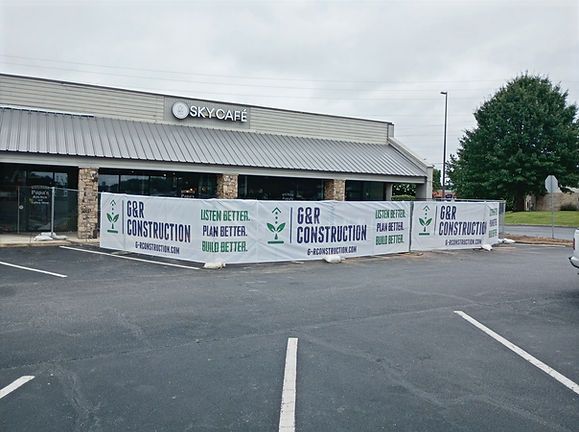Closed storefront with banner advertising “Best Prices on New Construction” in a parking lot