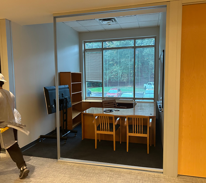 Study nook with desk, two chairs, monitor, and window overlooking a playground